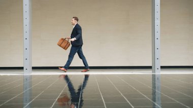 İş adamlarının bavul tutarken ve şehir merkezindeki iş yerine yürürken yan görüntüsü. Profesyonel proje yöneticisi dışarıda resmi takım elbise giyerken toplantıya gidiyor. Urbane.