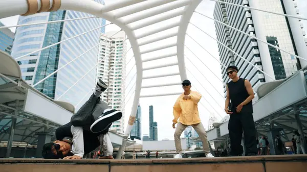 当亚洲嬉皮士在被低角度摄像机环绕的城市里表演自由式步法时 一群专业的街头舞者欢呼雀跃 突破舞蹈的概念 2024年户外运动 神气活现 — 图库照片