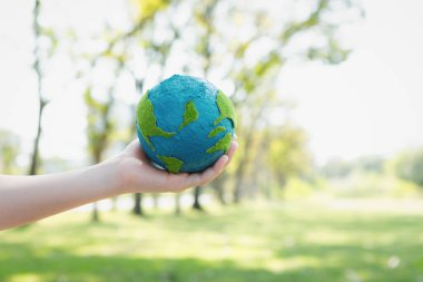 Dünya gezegenini ESG ilkesi ve çevre dostu enerjisiyle daha parlak bir gelecek için Dünya günü olarak el ele tutuşan genç çocuklar. Döngü