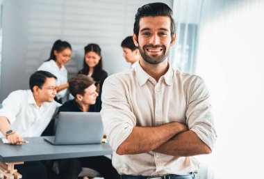 Ofiste çalışan iş arkadaşı ve iş adamlarının geçmişine sahip özgüven ve mutlu gülümseyen iş adamı portresi. Ofis çalışanı takım çalışması ve pozitif iş yeri konsepti. Tedbirli