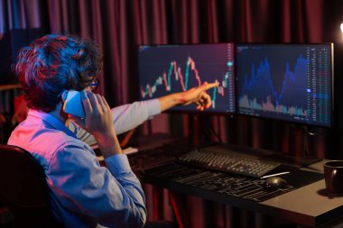 Genç tüccardan komisyoncuya, küresel piyasadaki kar döviz kuru yatırımına danışmanlık yaparak bilgisayar ekranında gerçek zamanlı olarak Neon Light Modern Office 'de. Borsa kavramı. Toplayıcı.