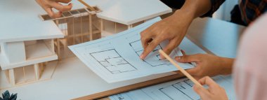 Mimari takım analizi ve ev modeli, plan ve mimari ekipmanlarla toplantı masasında ev inşaatı hakkında beyin fırtınası. Yaratıcı tasarım ve takım çalışması. Filizlenen.