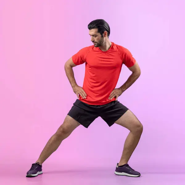 Full body length gaiety shot athletic and sporty young man with fitness warmup and stretching body for pre exercise posture on isolated background. Healthy active and body care lifestyle.