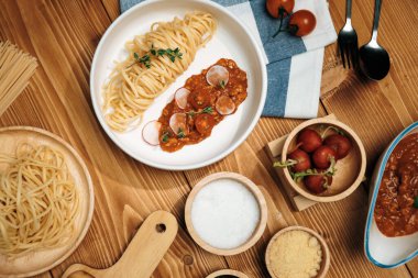 Lezzetli yiyecekler, ev yapımı spagetti, kıymalı domates sosu ve fesleğen fırlatma elementleri, şef masası dekoratif baharatlarla servis ediliyor. Varsayım.
