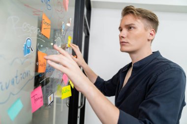 Kafkasyalı profesyonel iş adamının zihin haritası ve renkli yapışkan notlar kullanarak iş pazarlama fikrini kendine güvenle sunuşunun yakın görüntüsü. Proje konseptini başlat. Portre. Tertemiz..