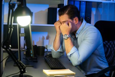 Çalışan bir işadamı, gece vakti projesiyle uykulu bir şekilde e-posta bilgilerinin modern işyerine gönderilmesini bekliyor. Uzaktan kumandalı çevrimiçi çalışmadan zaman içinde sıkılan serbest çalışan teması. Satılabilir.