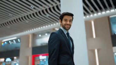 Beyaz arka planda dururken kameraya bakan bir iş adamı. İş elbisesi giyerken kameraya gülümseyen başarılı adamın yakın çekimi. Yönetici, kameraya bak. Hareket eden kamera. Sevinçli..