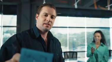 Bir grup iş adamı modern ofisteki yaratıcı pazarlama stratejisini tartışıyor. İş adamları cam tahtada yapışkan notlar kullanarak finansal plan üzerinde çalışıyor. Yönlendirici.