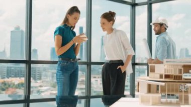 Proje planına bakarken tasarımla ilgili düşünen, paylaşan, beyin fırtınası yapan profesyonel mimar mühendis takımı. Genç bir mimar, genç ve güzel bir menajer not alırken elinde bir plan tutuyor. İzleme