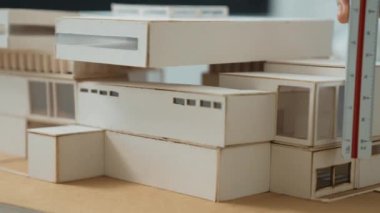 Cetvel ölçü evi modelini kullanan yetenekli profesyonel mühendis elini kapatırken, genç yetenekli mimar da taslak çiziyor. Yaratıcı ve profesyonel tasarım. Eline odaklan. Tertemiz..