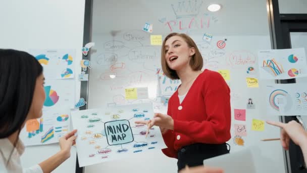 プロの若手リーダーは ビジネスミーティングでマインドマップを使用して 彼女の戦略について議論し 脳の嵐に囲まれてビジネスアイデアを提示します インマキュライト — ストック動画