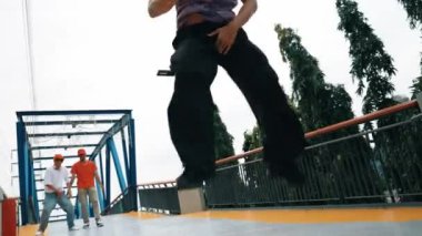 Panorama 'da hipster şık kıyafetler giyer ve dondurucu poz verir. Bir grup profesyonel dansçı break dans yaparken seçkin adam break dans yapıyor. Açık hava sporu 2024. Yumuşak bir şekilde.