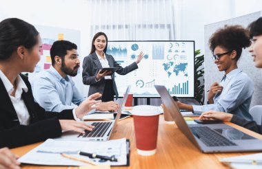 Genç Asyalı iş kadını modern toplantıda TV ekranında veri analizi paneli sunuyor. Bir grup iş adamıyla konferans odasında iş sunumu. Uyum