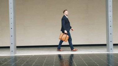 İş adamlarının bavul tutarken ve şehir merkezindeki iş yerine yürürken yan görüntüsü. Profesyonel proje yöneticisi dışarıda resmi takım elbise giyerken toplantıya gidiyor. Urbane.