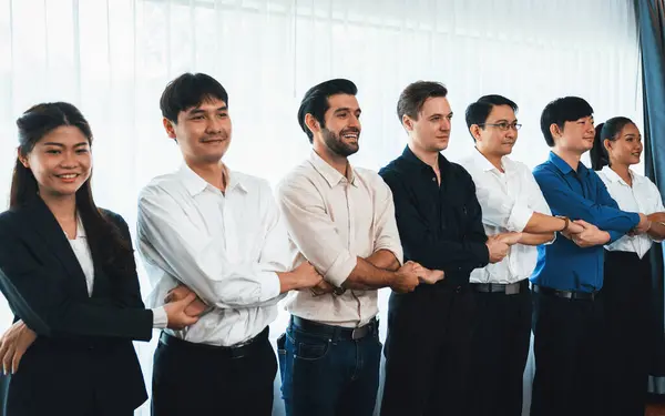 Business team standing, join and link hand together in line symbolize successful business partnership and professional synergy with diverse culture group people cooperation. Prudent