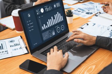 Çok ırklı analist ekibi toplantı masasındaki finansal verileri analiz etmek için BI Fintech yazılımı kullanıyor. Finansal konsol veri ekranında pazarlama göstergesi için analiz edilmiş grafikle birlikte. Uyum