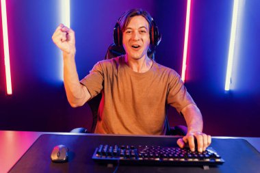 Kazanmak için çevrimiçi oyun oynayan akıllı flama makinesinin sunucu kanalı, neon ışıklı odada seçilen takım yarışması için izleyicilerle birlikte canlı yayında canlı yayında kulaklık takıyor. Bireysel.