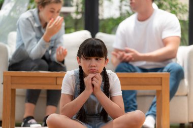 Stresli ve mutsuz bir genç kız oturma odasında ebeveyninin tartışması yüzünden gerginlik içinde ağlıyor. Sağlıksız ev hayatı ve travmatik çocukluk depresyona dönüşür. Eşzamanlama
