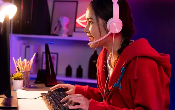 Улыбчивая Красивая Азиатская Девушка Играющая Онлайн Игру Наушниках Разговаривает Зрителями — стоковое фото