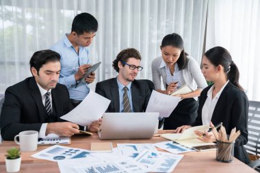 Ofis masasındaki finansal veri raporlarını analiz eden çeşitli bir grup iş analisti. Stratejik pazarlama planlaması için iş istihbarat analizine göre grafikler ve grafikler.