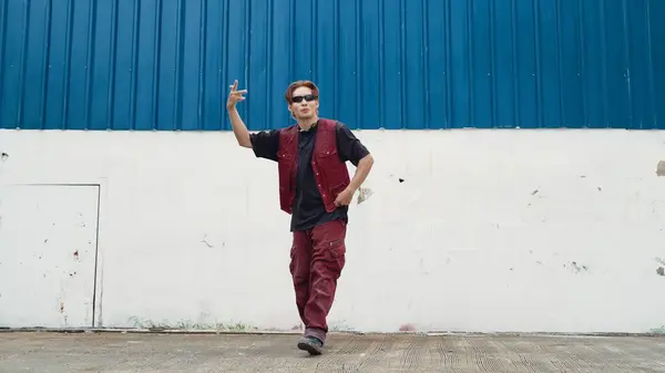 英俊的街舞选手在白色的后方操练霹雳舞 体育男子穿着嘻哈风格 同时移动脚步声到蓝色背景的街道上的音乐 2024年户外运动 奋斗者 — 图库照片