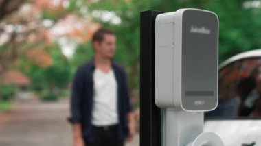 EV otomobili, tatilde Ulusal Park Sonbahar Ormanı 'nda çevre dostu elektrikli araçla seyahat eden çifte ait piller için elektrik yüklüyor. Yükselt