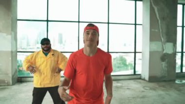 Çok kültürlü hipster grubu kameraya bakarken gökyüzü avcısıyla ya da şehir manzaralı bir binada break dans yapıyorlar. Sokak dansçısı ekibi dansçı performansına bakıyor. Açık hava sporu 2024 hiphop..