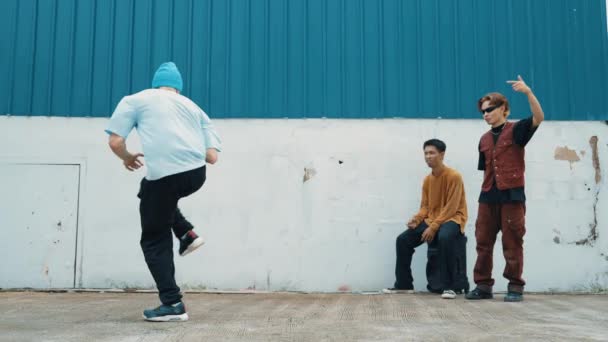 年轻的街头舞者跳嘻哈风格的舞 多文化的朋友在墙后欢呼 迷人英俊的男人在蓝色背景的大街上伸出手来 户外运动2024 — 图库视频影像