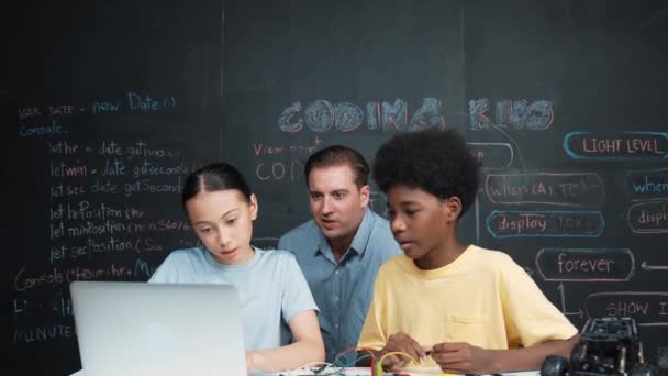 白种人老师一边指著笔记本电脑一边教工程代码 教师在使用笔记本电脑的同时 对高中学生的学习和学习编程系统感到满意 — 图库视频影像