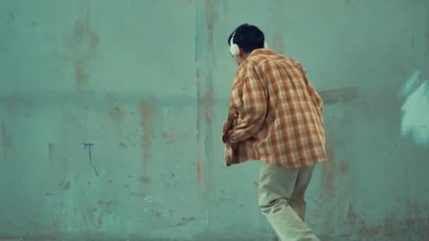 Çimento Arka Planında Kulaklıktan Müzik Dinlerken Sıradan Sokak Dansı Yapan — Stok video