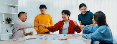 Heyecanlı ve mutlu bir şirket çalışanı başarılı bir stratejik iş pazarlama planlaması yaptıktan sonra kutlama yapıyor. Takım çalışması ve olumlu tutum verimli ve destekleyici bir iş yeri yaratır. Sinerjik