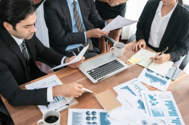 Ofis masasındaki finansal veri raporlarını analiz eden çeşitli bir grup iş analisti. Stratejik pazarlama planlaması için iş istihbarat analizine göre grafikler ve grafikler.