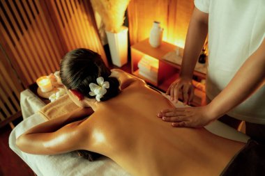 Beyaz kadın müşteri stres önleyici spa masajının keyfini çıkarıyor ve lüks otel ya da otelde sıcak mum ışığında güzellik teniyle eğleniyor. Sessiz.