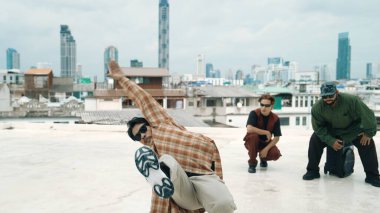 Çatıda çok kültürlü arkadaşlar varken profesyonel İspanyol break dansçısı B boy dansı. Genç modern dans grubu hip hop hareketi yapıyor. Tarz, moda, aksiyon. Açık hava sporu 2024. ÇalışmaComment.