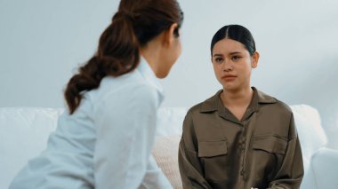 Psikologla ruh sağlığı terapisi gören üzgün travma sonrası stres bozukluğu olan bir kadın. Yaşam sonrası depresyon veya keder. Hayal kırıklığına uğramış genç bir kadın klinikteki duygular hakkında Vivancy psikoloğuyla konuşuyor.