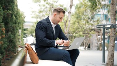 Kafkasyalı iş adamları laptopta çalışırken saati kullanarak toplantıyı hatırlatıyorlar. Proje yöneticisi, uzaktan kumandalı iş ekibiyle çalışırken bilgisayar yazma raporunu kullanıyor. Urbane.