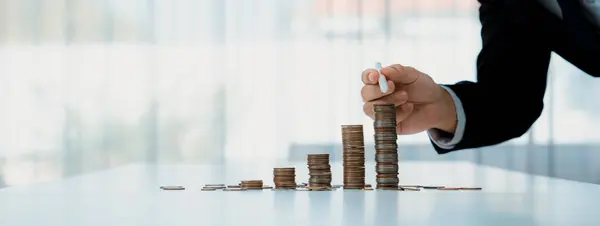 Growth coin stack symbolizing business investment and economic growth. Business people doing financial planning to achieve financial goal and contribute maximum profit gain . Shrewd