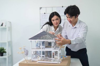 Kooperatif mühendis ekibinin portresi ev modelini ölçmek için cetvel ve mimari ekipmanlar kullanarak birlikte çalışıyor. Yaratıcı iş tasarımı ve takım çalışması konsepti. Tertemiz...