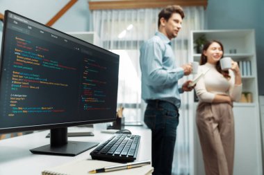 Yazılım, en yeni yaratıcı web sitesini çalışma masasında geliştiricilere karşı hazırlıyor. Kahve içiyorlar ve köşedeki bulanık arka planda yan görüşle birlikte tartışıyorlar. Varsayım.