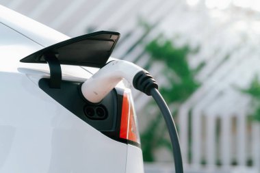 Kapalı el, şehrin park alanındaki şarj istasyonundan elektrikli araba aküsünü şarj etmek için EV şarj aleti yerleştirdi. Sürdürülebilir çevre dostu şehir yolculuğu için şarj edilebilir EV araba. Yararlı