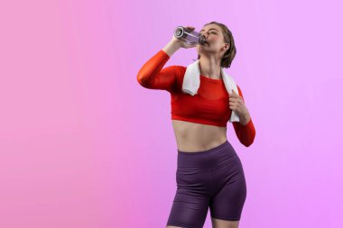 Vücut uzunluğunun tamamı atletik ve sportif genç bir kadını havluyla ve içme suyuyla izole edilmiş arka planda egzersiz yaparken çekilir. Sağlıklı aktif ve vücut bakımı yaşam tarzı.