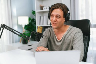 Sunucu kanalı, gülümseyen akıllı yayıncı kaydı, senaryosu ve akıllı telefonuyla sosyal medyada sohbet programı, kulaklık takarak modern ev stüdyosundaki video flamalarını kaydediyor. Bireysel.