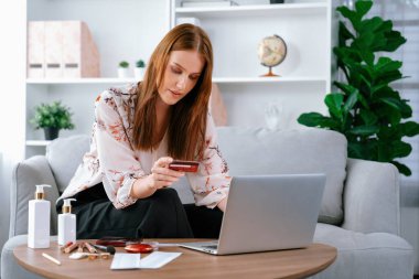 Genç mutlu kadın internetten alışveriş yaparak ürün satın alırken aynı zamanda internet üzerinden online ödeme sistemi ile çevrimiçi mağaza platformundan en yüksek siber güvenlik tarafından korunan ürünler sipariş ediyor.