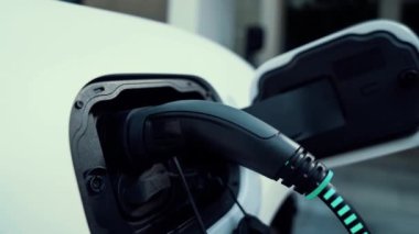 Elektrikli araba, gelecekteki ev şarj istasyonunda akıllı dijital EV batarya durumu hologramıyla şarj oluyor. EV arabasının teknolojik gelişimi ve sürdürülebilir gelecek için ev enerjisi altyapısı. İncelenme
