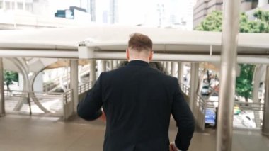 İşadamı merdivenlerden iniyor ve eve dönmek için acele ediyor. İş adamlarının takım elbise giyip terfi etmelerini ya da valizini tutarken satışlarını artırmalarını kutluyoruz. Urbane.