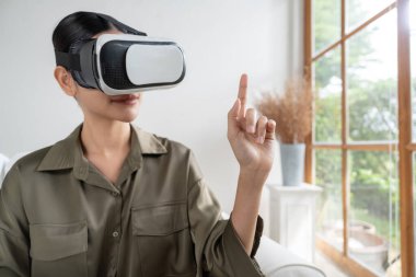 Sanal gerçeklik gözlüğü kullanan genç bir kadın online alışveriş deneyimi için evde. Sanal gerçeklik VR yeniliği dijital eğlence yaşam tarzı için optimize edildi.