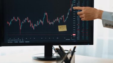 Menkul kıymetler borsası pazarlamasını analiz eden yavaş hareket eden bir yatırımcı. Monitörlere bakıyor. Zarar için mum bar fiyatını analiz ediyor ve kazanç ve kâr elde ediyor. Filizlenen