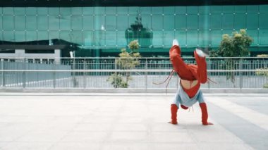 Sokak dansı yaparken enerjik adımlar atan yetenekli bir dansçı. Profesyonel hipster kameraya poz verirken şık kıyafetler giyiyor. Serbest stil dansı. Modern yaşam tarzı. Açık hava sporu 2024. Yumuşak bir şekilde..