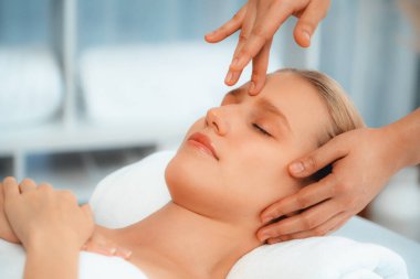 Kafkasyalı kadın stres önleyici kafa masajından ve lüks tatil beldesi ya da otel spa salonundaki modern ışık ortamında yüz güzelliği eğlencelerini şımartmaktan hoşlanıyor. Sessiz.