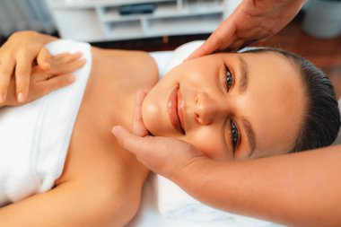 Kafkasyalı kadın stres önleyici kafa masajından ve lüks tatil beldesi ya da otel spa salonundaki modern ışık ortamında yüz güzelliği eğlencelerini şımartmaktan hoşlanıyor. Sessiz.